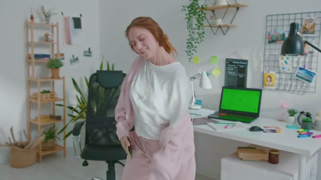 mujer diseñadora feliz bailando mientras escucha música