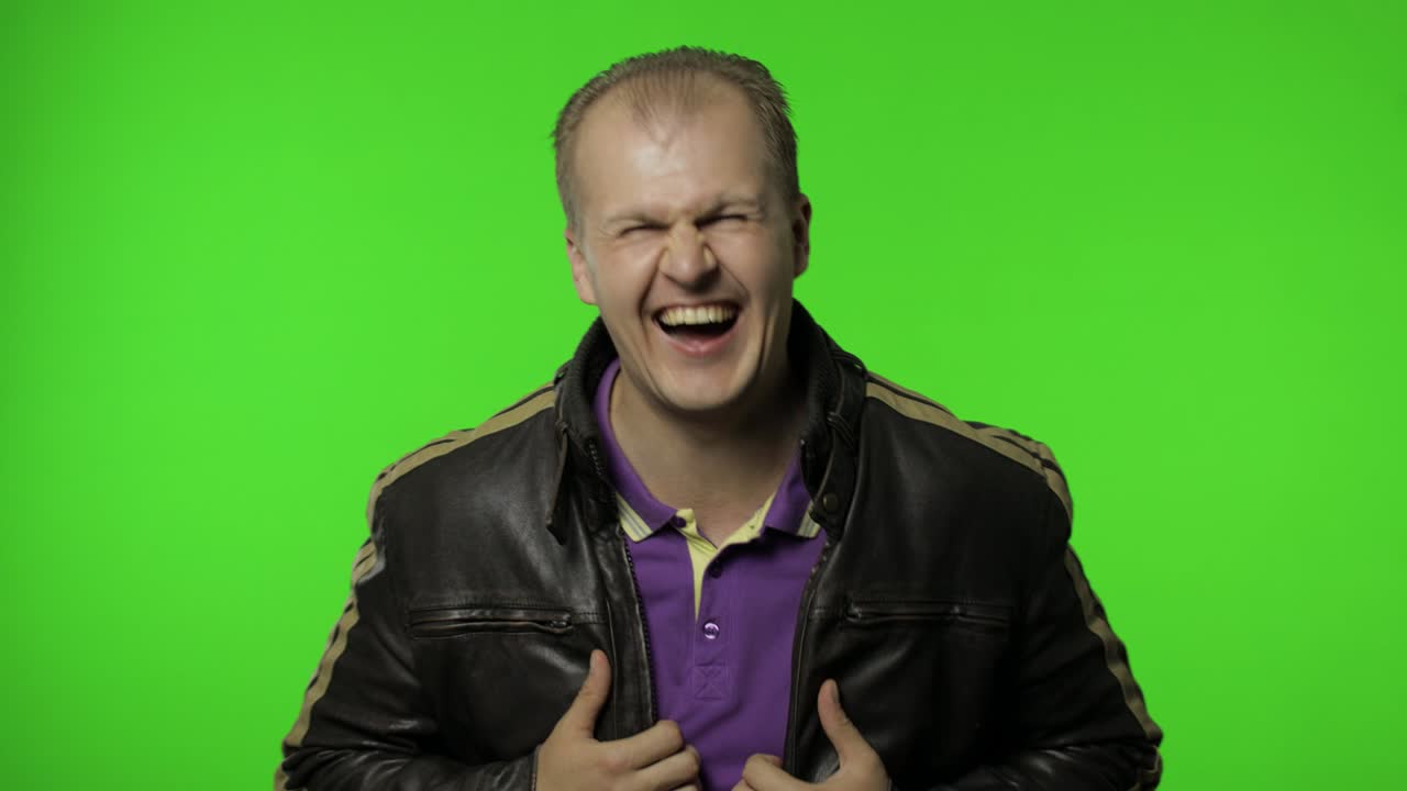 hombre sosteniendo el vientre y riendo en voz alta con lágrimas, sintiéndose despreocupado alegre después de escuchar un chiste gracioso