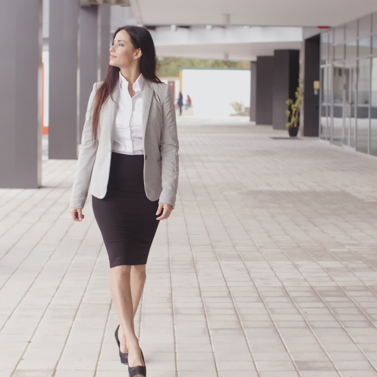 en smilende, optimistisk, professionel kvinde, der går.