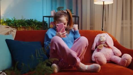 little kid girl use smartphone playing great big surprise good news celebrate online game win