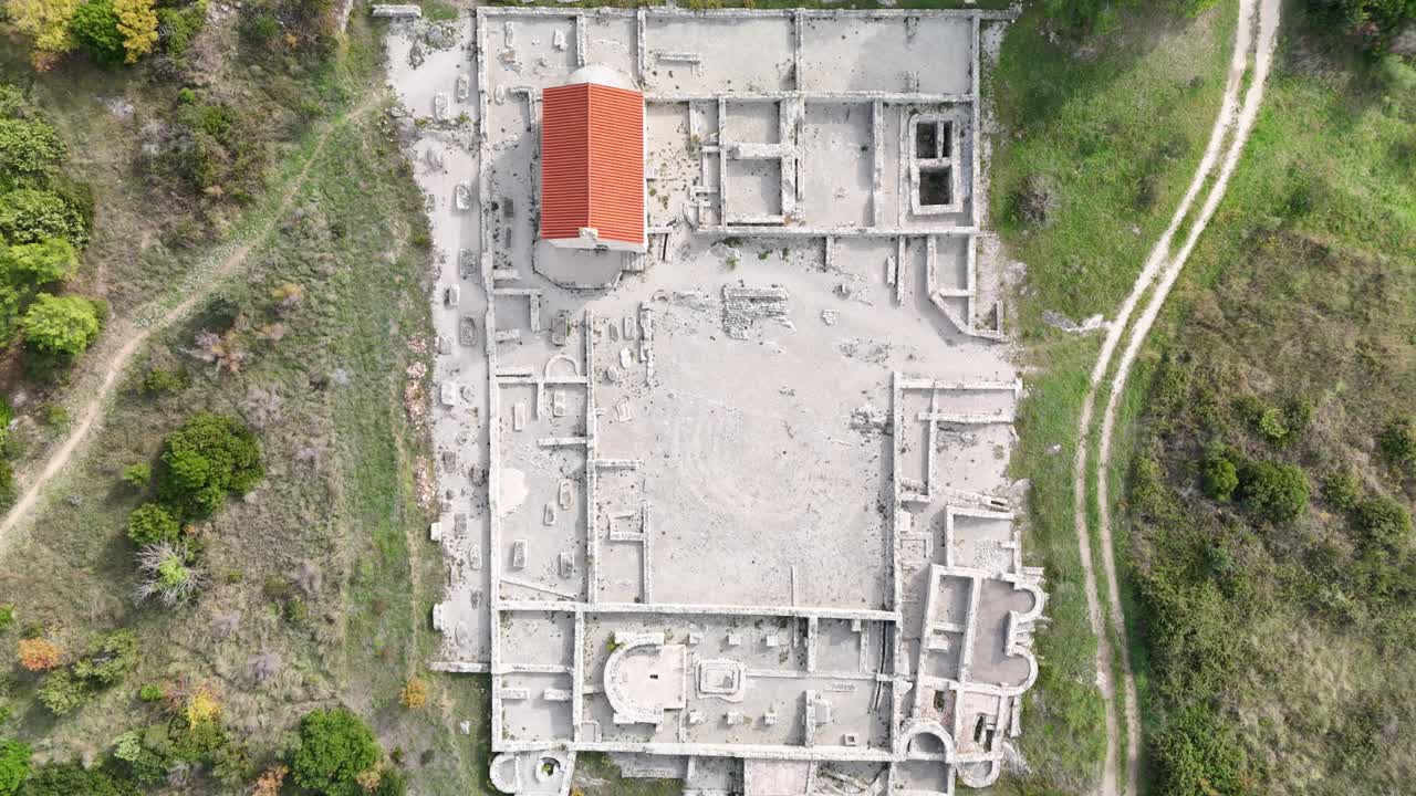 Landing with top-down drone view over the archaeological site in Ivinj near Pirovac, ancient villa rustica, early Christian building, St. Martin church, medieval cemetery