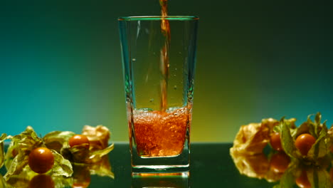 pouring a refreshing drink with cape gooseberries