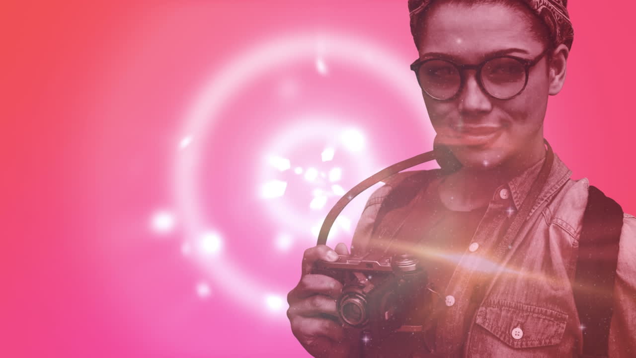 animación de chispas y luces sobre fotógrafa caucásica sobre fondo naranja