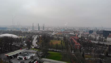 Aerial-panorama-of-Gdansk-city,-Poland-with-harbor-cranes-and-factory-chimneys