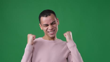 man celebrating victory over green background