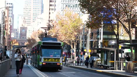 tram moves through busy melbourne street scene