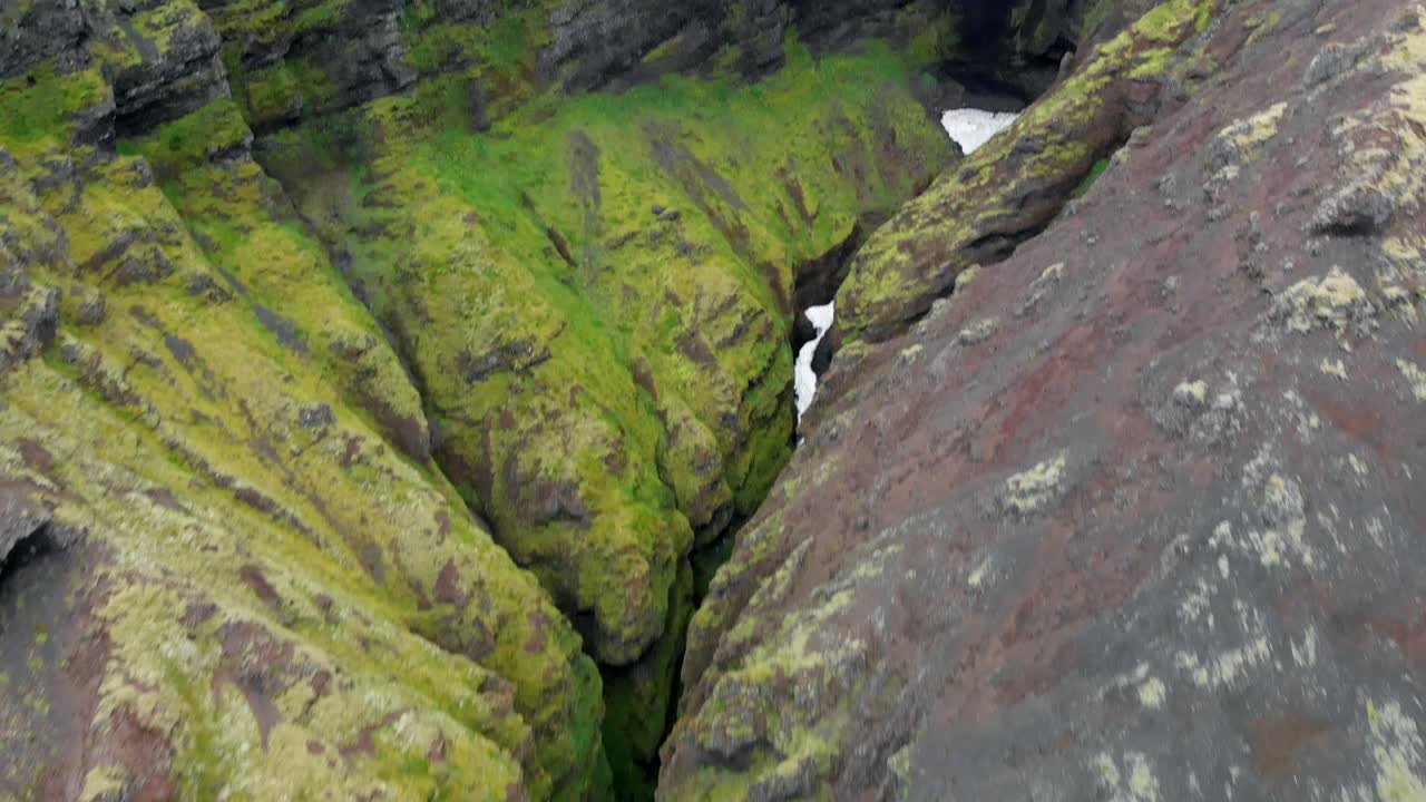 Aerial, tilt up, drone shot overlooking the Raudfeldsgja gorge, on Botnsfjall Mountain, overcast day, in Snaefellsnes, in Iceland