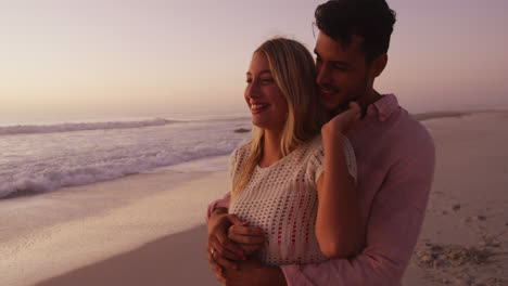 Pareja-Caucásica-Disfrutando-Del-Tiempo-En-La-Playa-Durante-La-Puesta-De-Sol