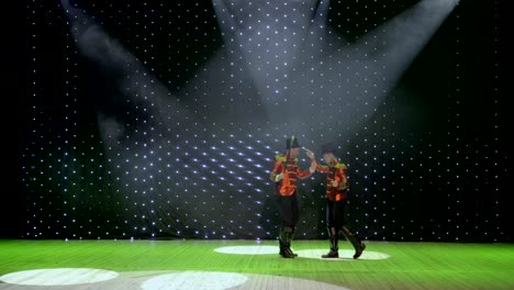 two handsome men wearing tail-coats and cylinders are dancing on stage