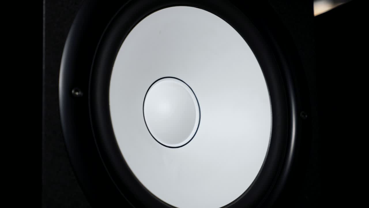 close up de mover sub-woofer em estúdio de gravação. alto-falante branco pulsando e vibrando de ouvir música alta em baixa frequência. trabalho de membrana de alto-falantes de alta fidelidade moderna. movimento lento