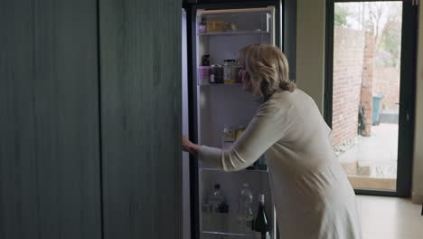 woman opening a refrigerator filled with food