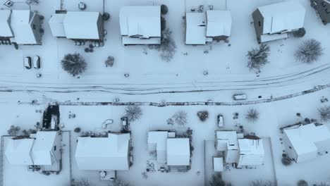 snowy aerial view of a suburban neighborhood with distinct road patterns and houses, captured in the usa