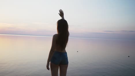 happy beach woman waving hands hello saying on hawaii. portrait of multiracial asian caucasian woman on beach. hello summer concept