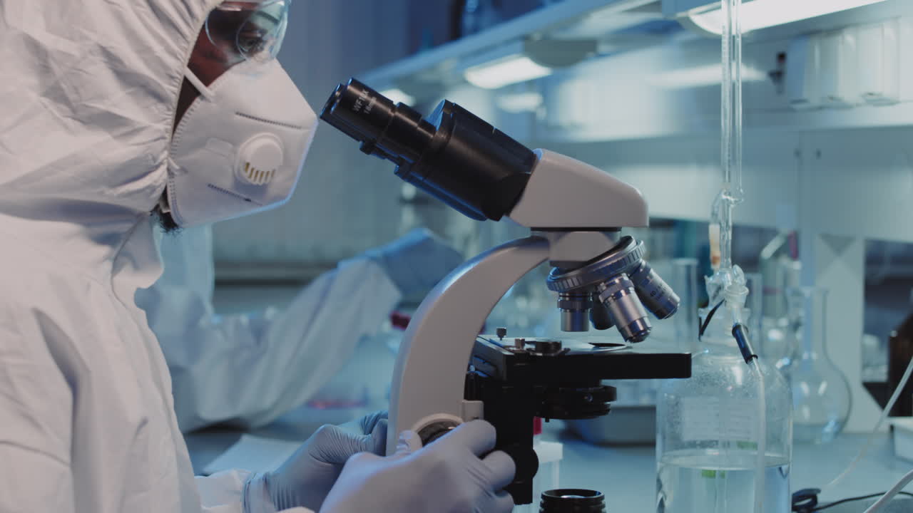 Slowmo of Epidemiologist Putting Sample under Microscope