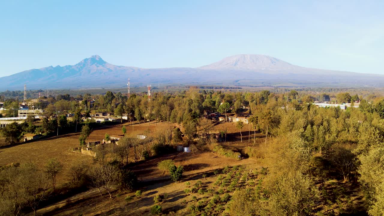 amanecer paisaje de kenya con una aldea, kilimanjaro y parque nacional de amboseli - seguimiento, vista aérea de avión no tripulado