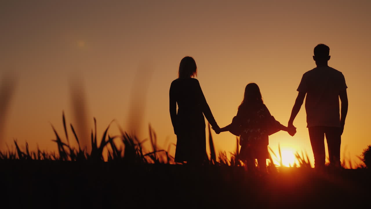 아이를 둔 부모는 행복한 가족의 손을 잡고 일출을 감상하는 그림 같은 곳에 서 있습니다