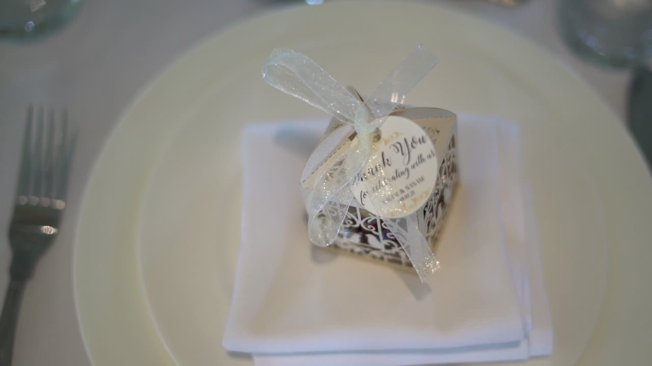 Un pequeño regalo en la cena de boda, colocado en un plato en la mesa del comedor.