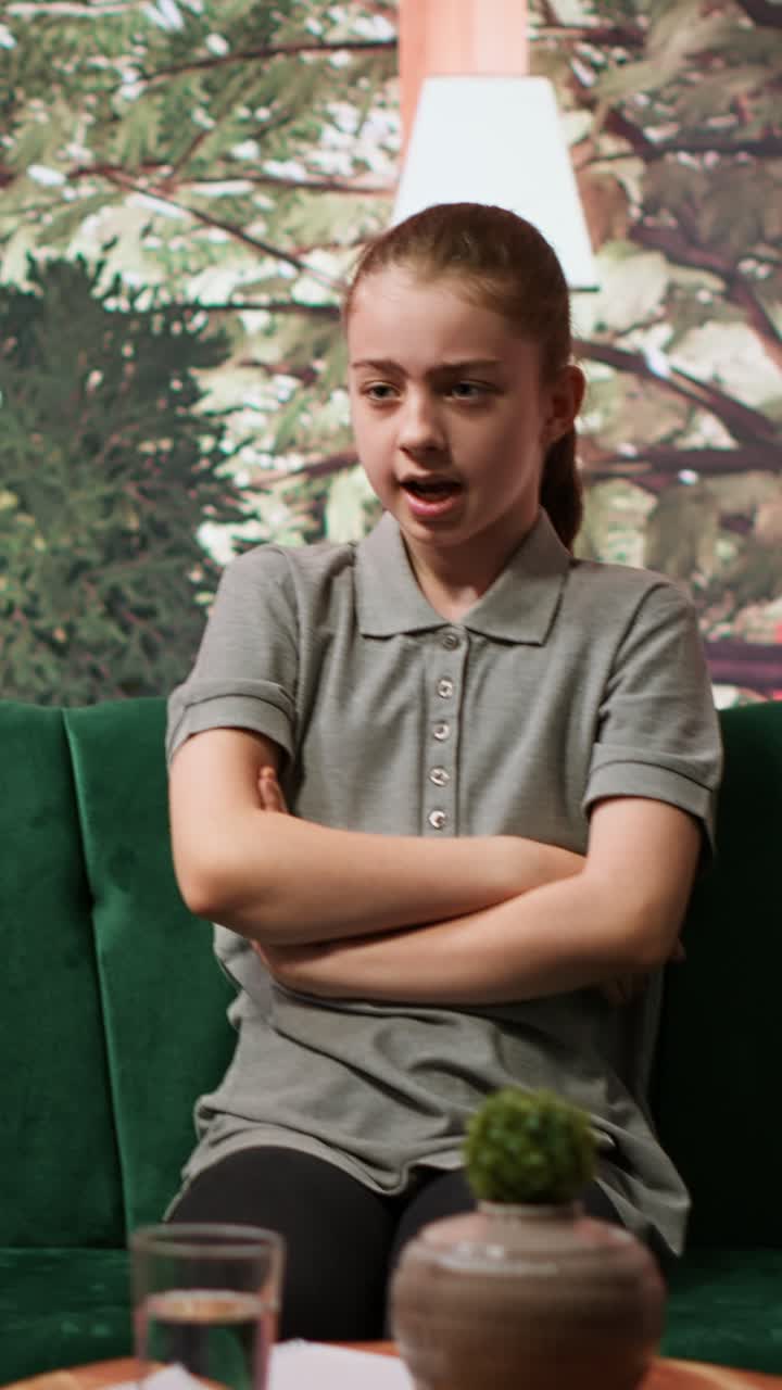 Upset Young Girl Talking and Gesturing on Green Couch