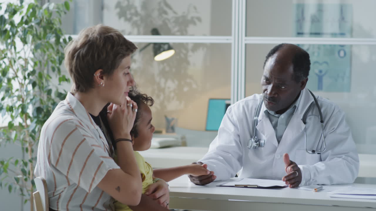 A doctor examining a child with their mother in the office