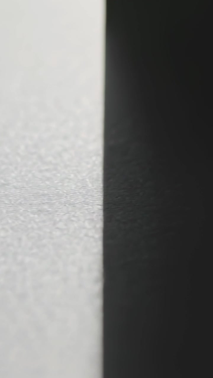 Vertical video: By tiny shifts camera filming closeup seam showing grain and dark panel, copy space