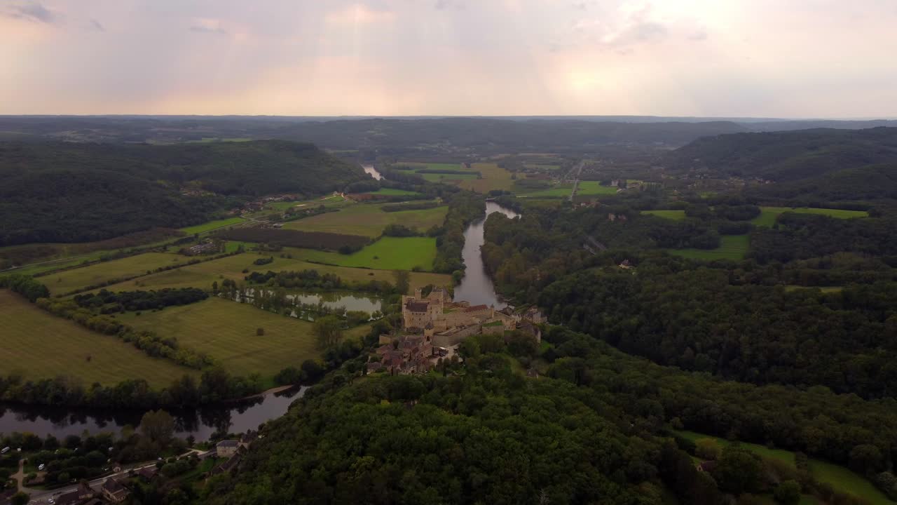 Aerial footage drone fly above of Beynac et cazenac france medieval small stone village in the dordogne forest historical site at sunset