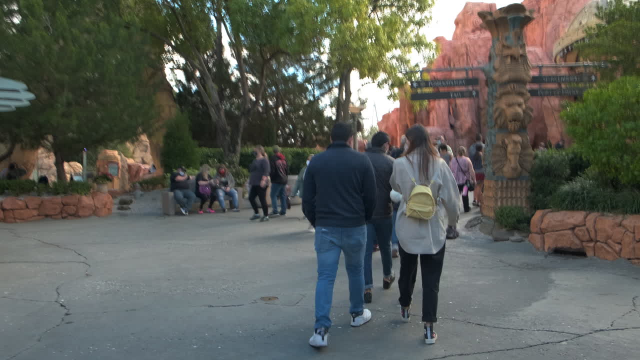 Pov forward walk through the famous Universal Orlando Theme Park during coronavirus pandemic in America. All people wearing protective masks.