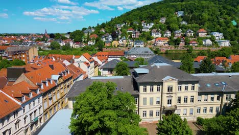 4k aerial drone video of historic homes and churches along the neckar river in heidelberg, germany