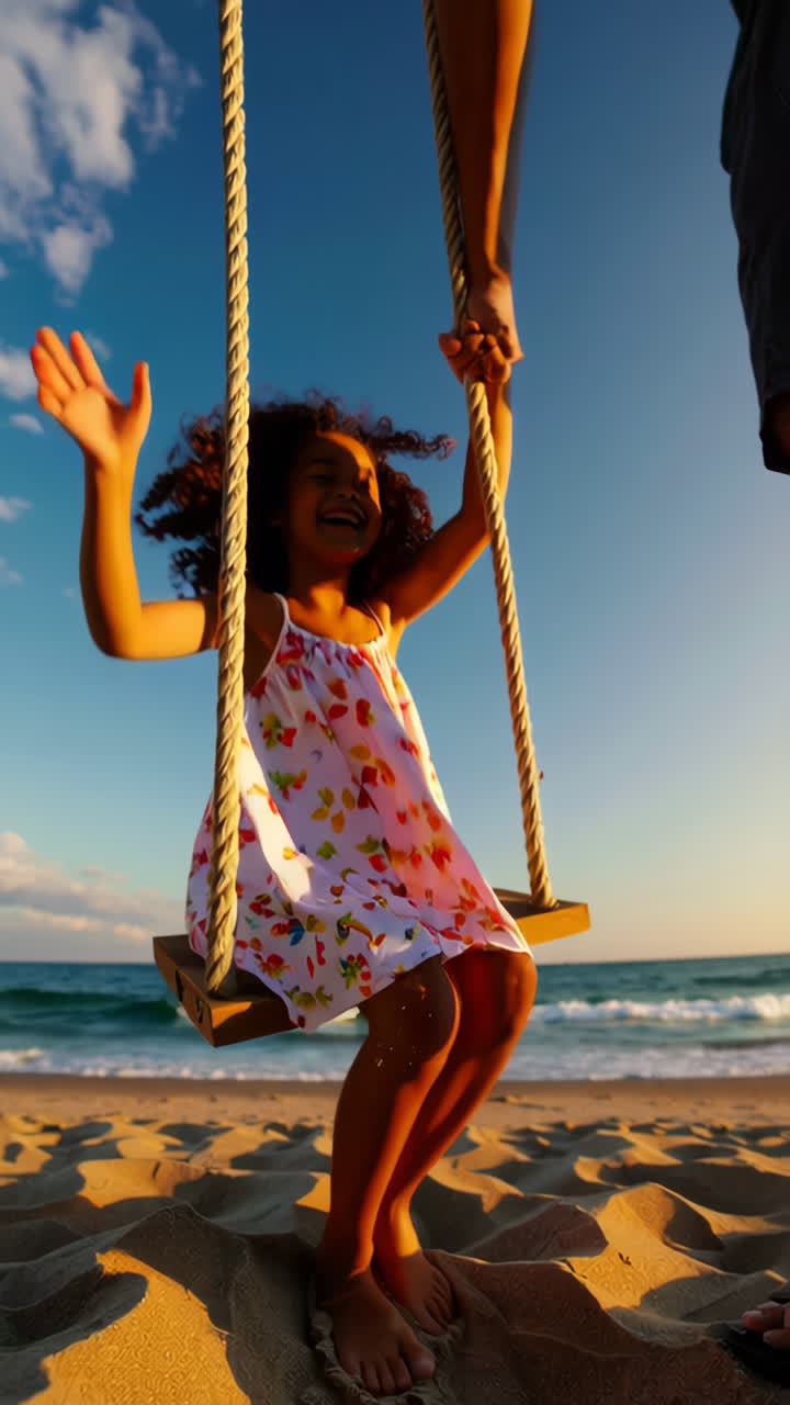 Bambino che si dondola felicemente su una spiaggia al tramonto
