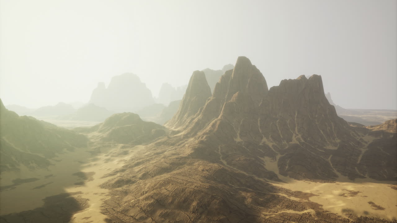 Majestic mountain range rises through a serene desert landscape at dawn