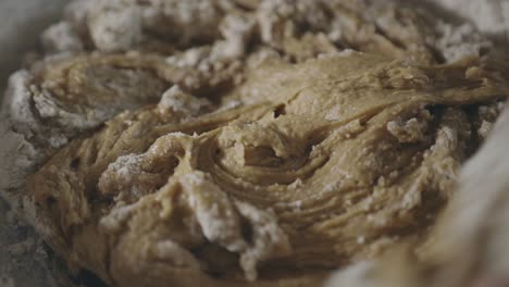 mixing cookie batter and flour using a wooden spoon in the kitchen - close up