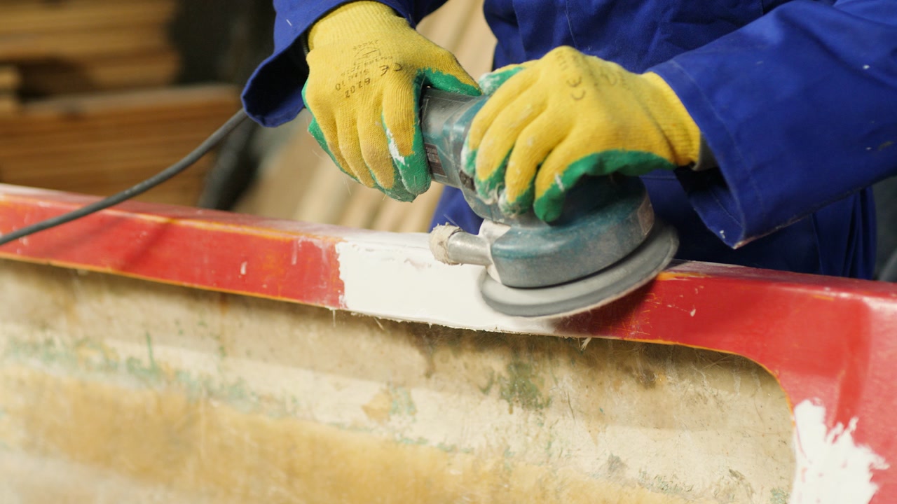 Sanding filler fiberglass boat gunwale using electrical sander