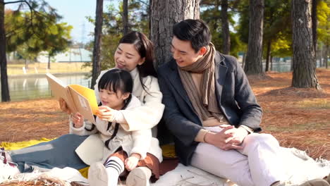 happy family in the outdoor outing having a picnic in the park, concept of destination, family travel and summer vacation or holidays