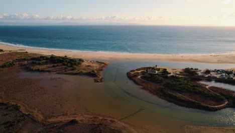 toma de drones de un río que desemboca en el mar de alborán en tarifa, españa