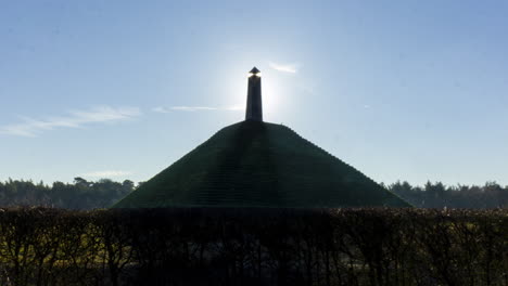 medium shot time lapse of sun appearing behind obelisk on austerlitz pyramid. the piramide van austerlitz is a monument built in 1804 as a tribute to napoleon bonaparte.