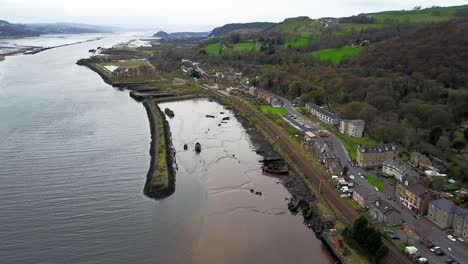 aerial fly over of a stranded boat wreckage in sand at bowling harbour in west dunbartonshire scotland