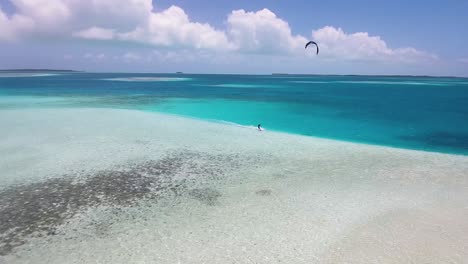 un dron disparó a dos hombres haciendo kitesurf uno frente al otro, se encontraron y cruzaron cometas sobre el mar en aguas turquesas y cristalinas