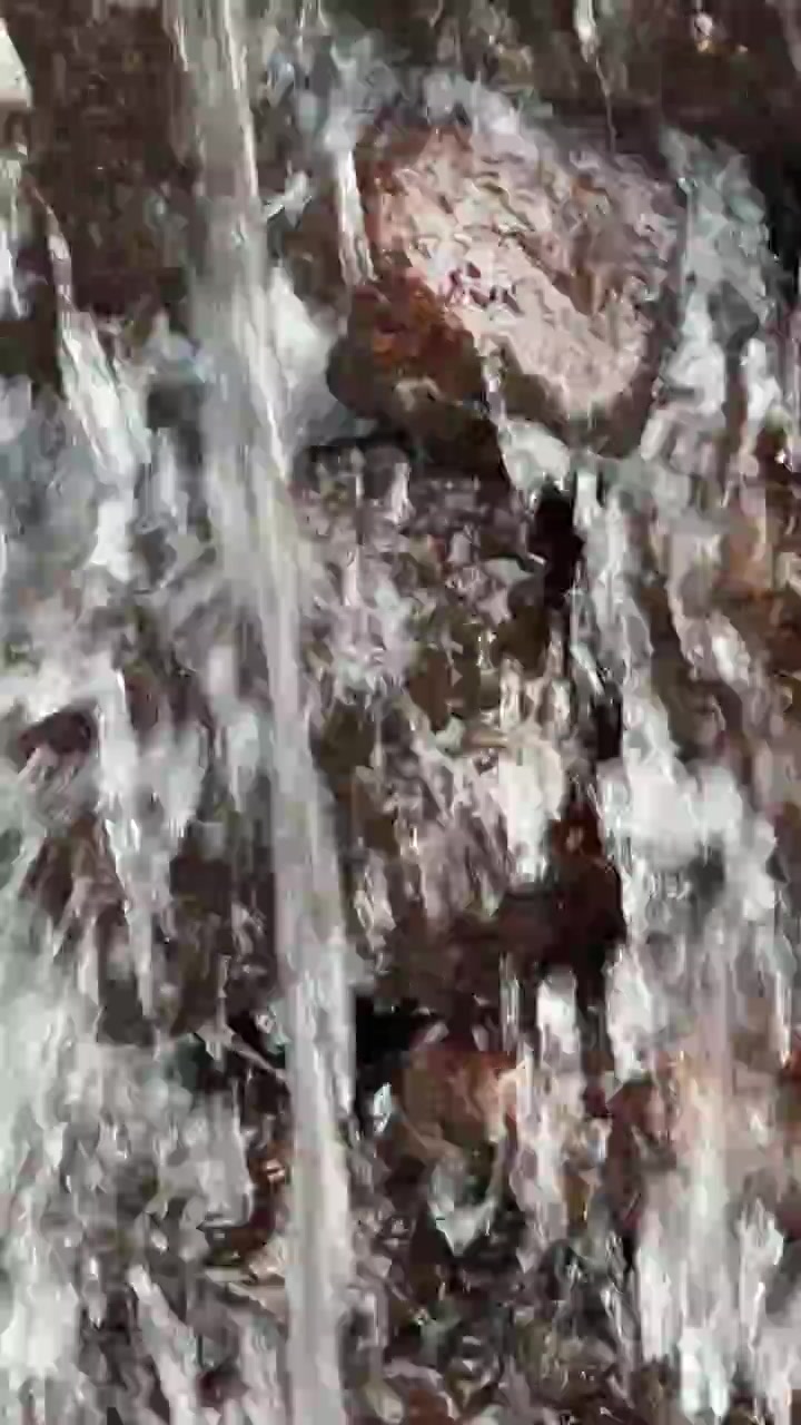 Acqua che scorre su rocce scure in un piccolo ruscello
