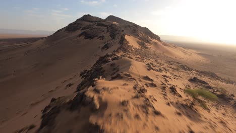 Aerial-drone-fpv-over-high-rocky-dune-near-Zagora-in-Morocco-desert