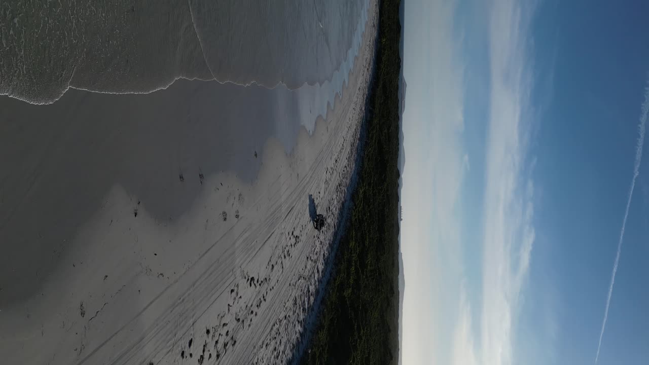 은 날 와일리 베이의 모래 해변에서 차의 수직 드론