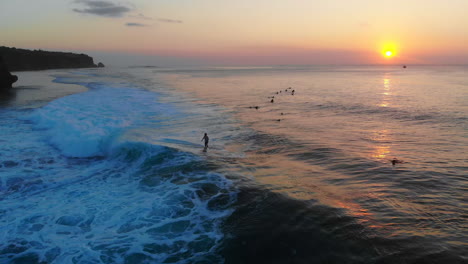 Ein-Surfer,-Der-Eine-6-7-Fuß-Welle-Mit-Dem-Sonnenuntergang-Im-Hintergrund-Erwischt,-Dann-Kommt-Er-Wenige-Sekunden-Später-An-Die-Spitze-Der-Welle-Und-Hebt-Beide-Hände-–-Und-Zeigt-Der-Kamera:-„Ich-Habe-Es-Geschafft“