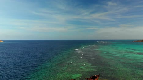 Epic-revealing-shot-of-a-shallow-reef-which-claimed-a-shipwreck-in-the-Caribbean-sea