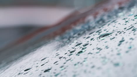 macro close up shot of raindrops falling on car windshield