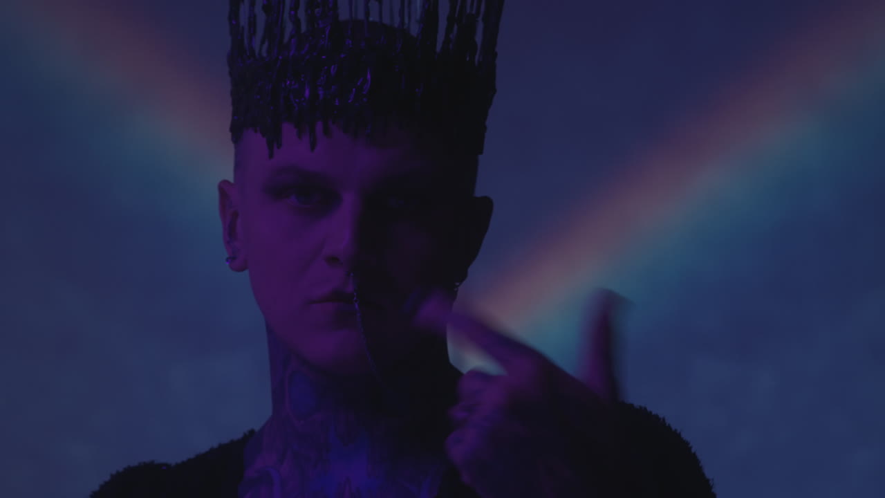 Uomo con corona gotica che balla in uno studio buio