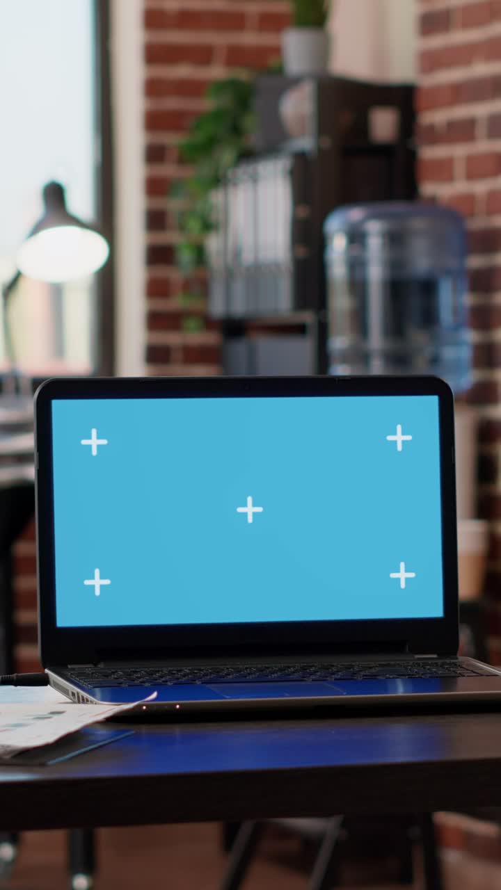 Laptop with green screen in an office