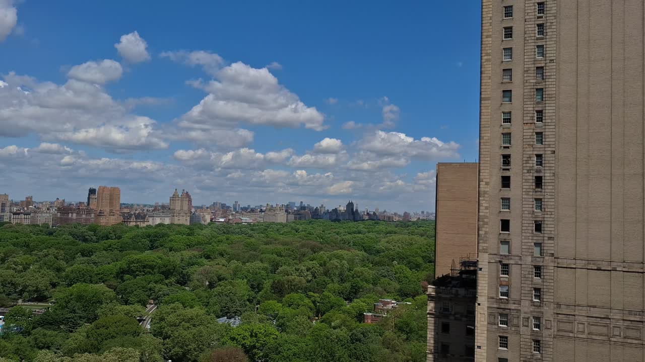 A view of modern skyscrapers with glass facades reflecting the blue sky and surrounding cityscape in Midtown Manhattan, New York, United States