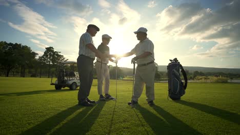 4k group of asian men golfer shaking hand after finish the game on golf course at summer sunset