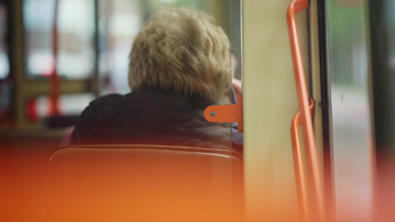 Vista interna con messa a fuoco morbida di un passeggero seduto all'interno di un veicolo di trasporto pubblico
