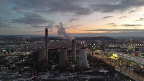 industrial chimneys emitting smoke over iași at sunset