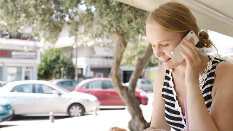 woman eating refreshments and using a mobile