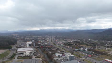 aerial shot of piegon forge, tn on january 1st 2025 with snow covered smoky mountains in the background.